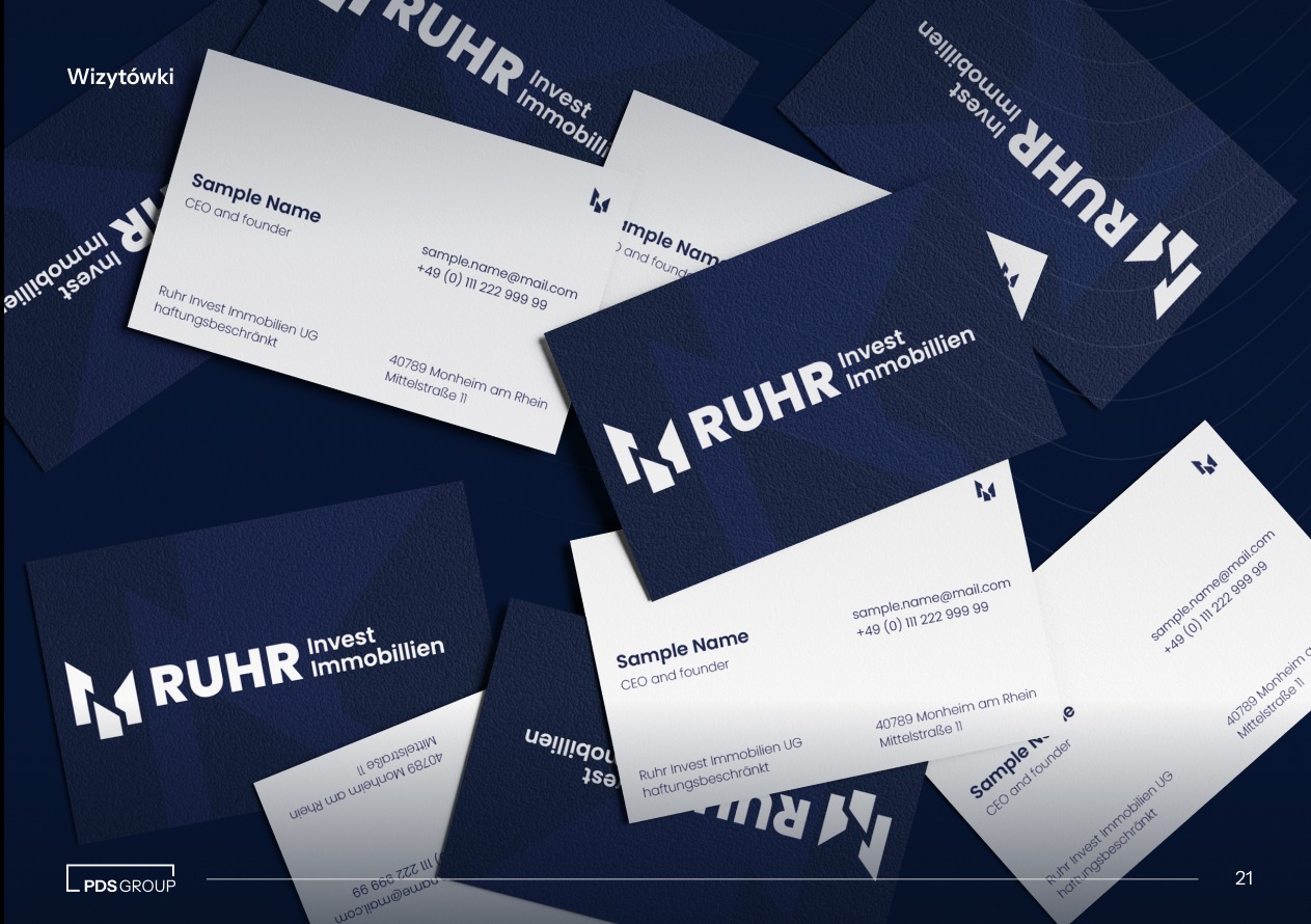 Stos wizytówek firmy Ruhr Invest Immobilien z logo w kolorach białym i granatowym, ułożonych pod kątem na ciemnym tle. Widoczne dane kontaktowe i adres.