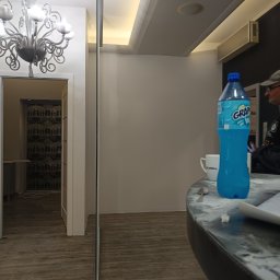 Bartosz Piszczyk - Wnętrze mieszkania po remoncie: parkiet, ściany w jasnych barwach, ozdobny żyrandol, widok na pokój z tapetą. Widoczne ślady po pracy na blacie.