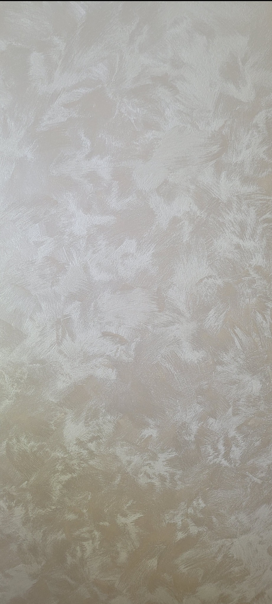 Dekoracyjna ściana w odcieniach beżu z efektem strukturalnym, imitującym delikatne pociągnięcia pędzlem. Subtelne przejścia kolorystyczne tworzą unikalny wzór na powierzchni.