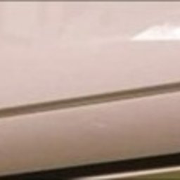 KATARZYNA FIEDUNA HADES-GENEZA888 - Biały klimatyzator marki Kaisai, widoczny z bliska, z delikatnym oświetleniem podkreślającym jego gładką powierzchnię.