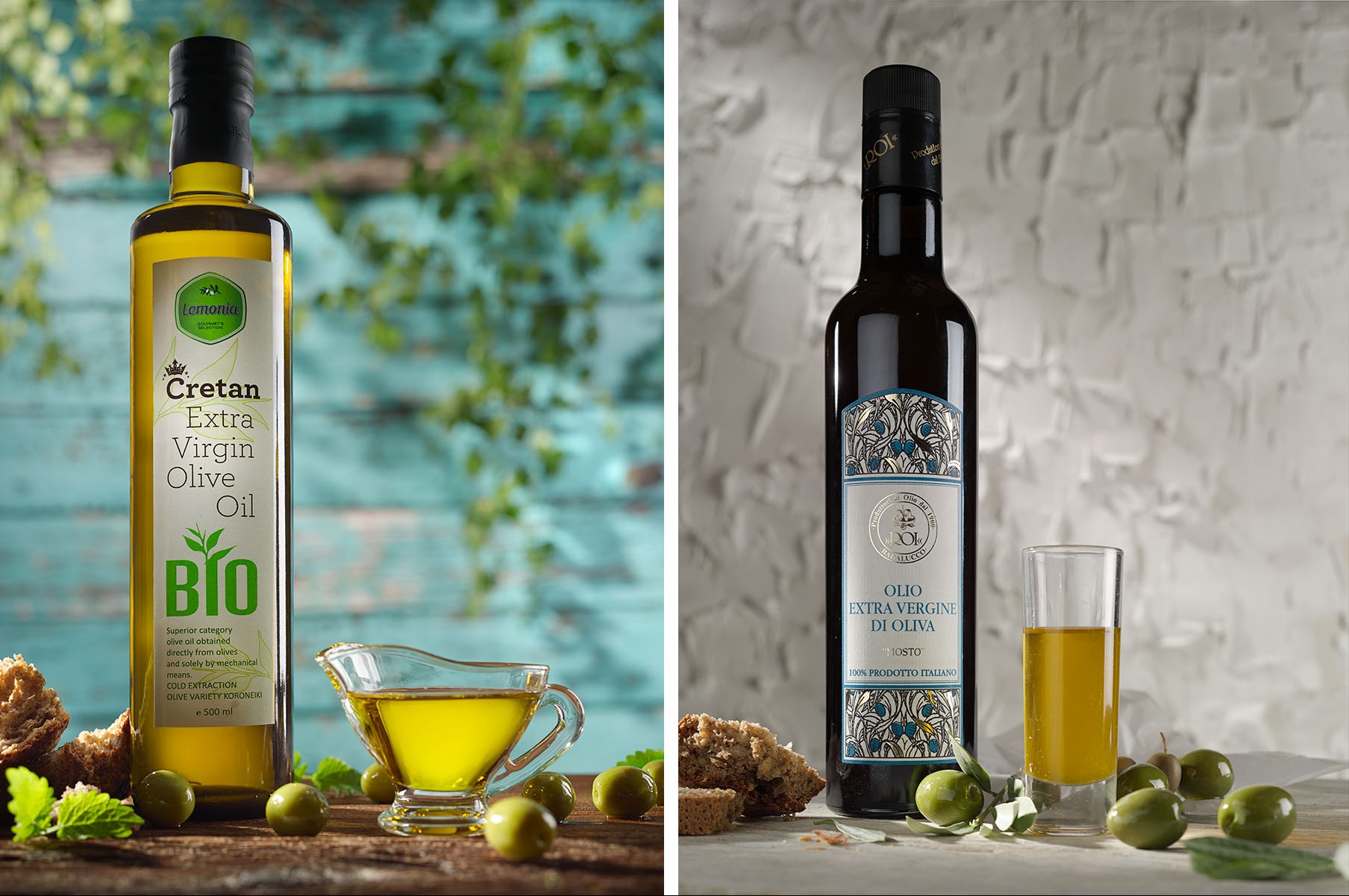 Dwie butelki oliwy z oliwek extra virgin, kreteńska i włoska, z oliwkami i chlebem na drewnianym blacie. Kreteńska z zielonymi elementami, włoska z niebieskimi.