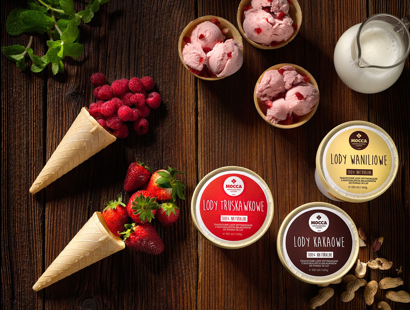 Kompozycja z lodami Mocca: truskawkowe, waniliowe, kakaowe. Wafelki z malinami i truskawkami, dzbanek mleka na drewnianym stole, fotografia produktowa.