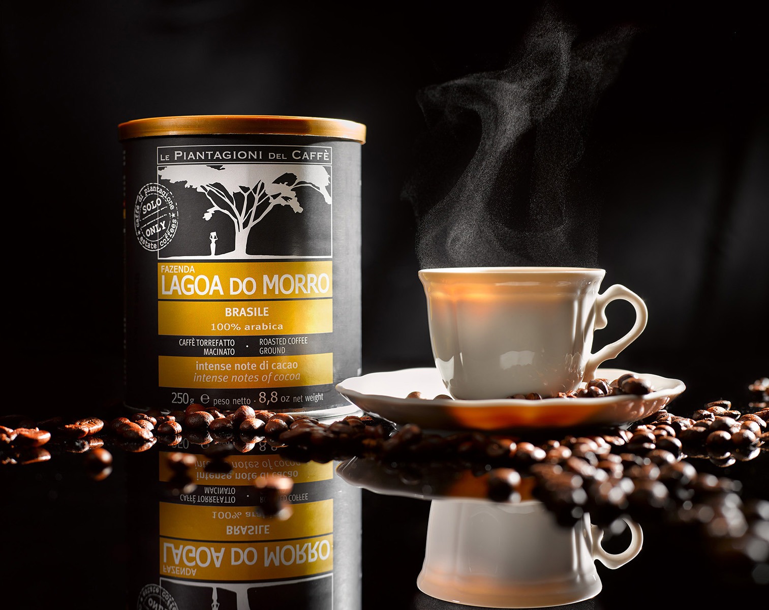 Zdjęcie produktowe: puszka kawy Lagoa do Morro obok filiżanki z parującą kawą, otoczone ziarnami kawy na błyszczącym tle. Ciemne tło i ciepłe światło.