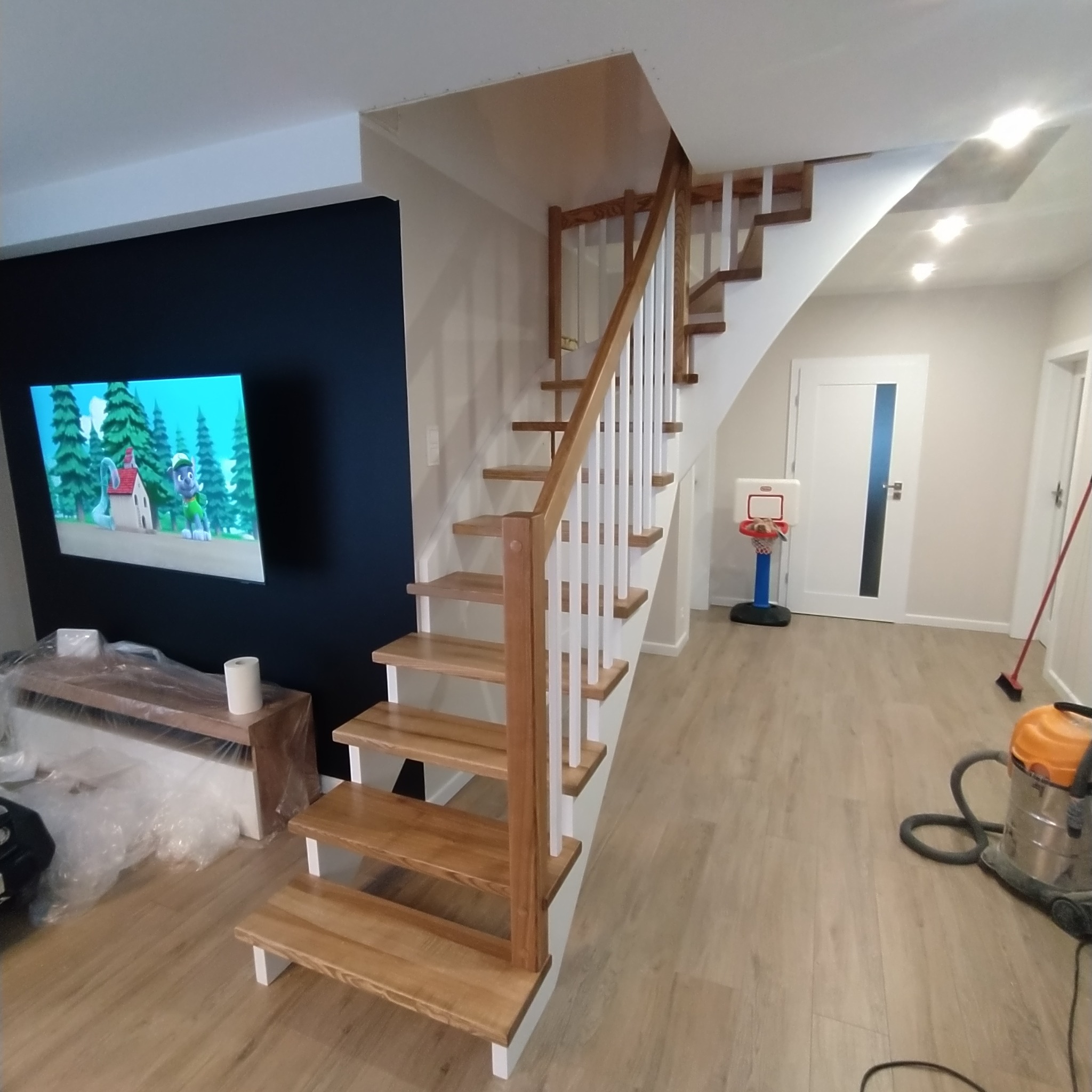 Schody jesionowe naturalne drewno z białymi dodatkami.