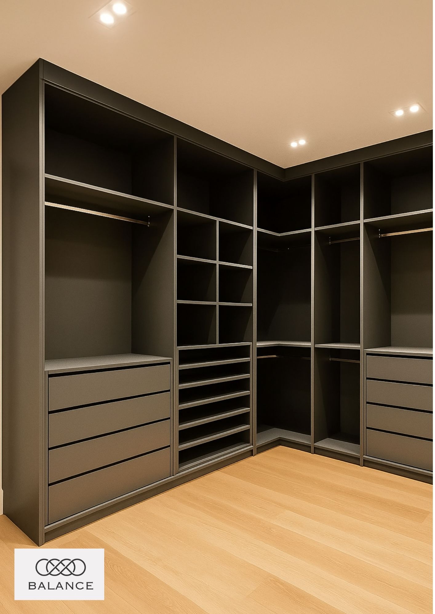 Funkcjonalna, grafitowa szafa wnękowa na wymiar z szufladami i półkami, oświetlona punktowo, na jasnej drewnianej podłodze. Widok z perspektywy wnętrza szafy.