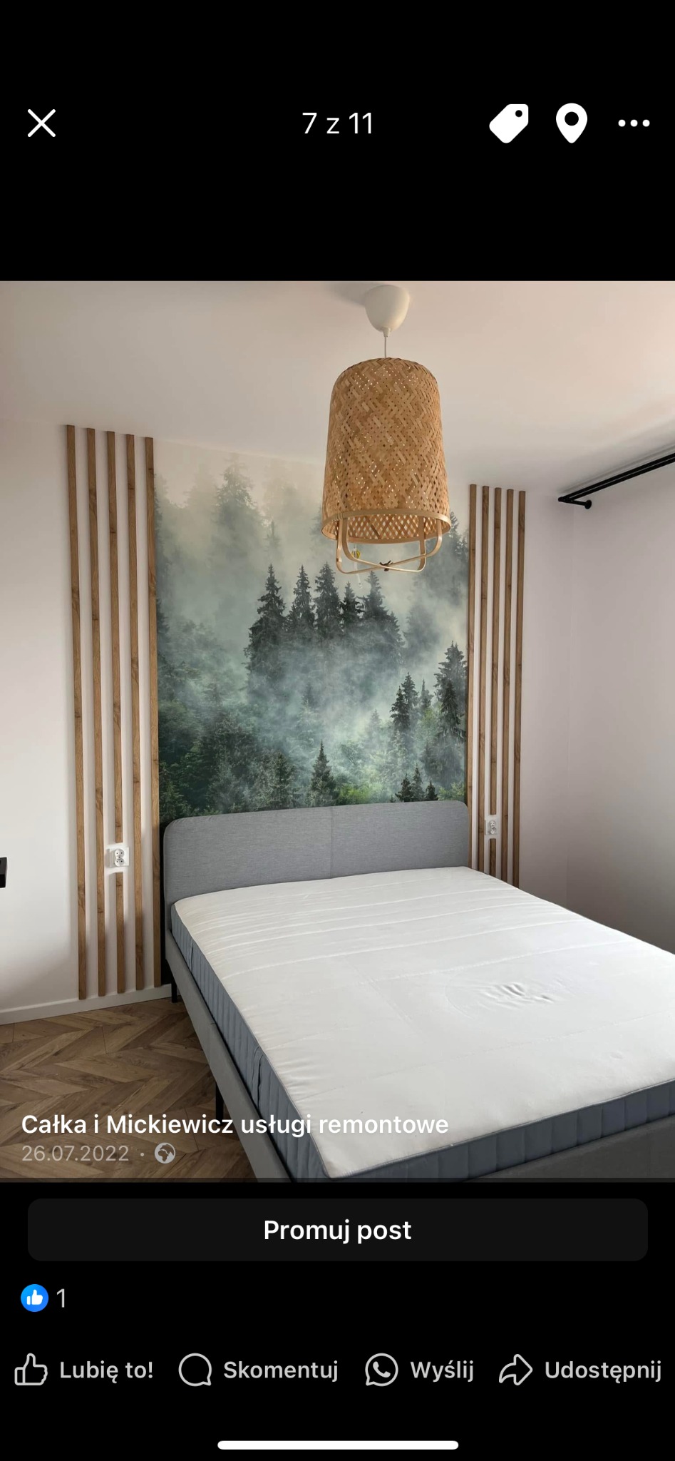 Sypialnia po remoncie: łóżko z szarą ramą, drewniane lamele na ścianie z fototapetą lasu, pleciona lampa. Parkiet na podłodze. Nowoczesny design.