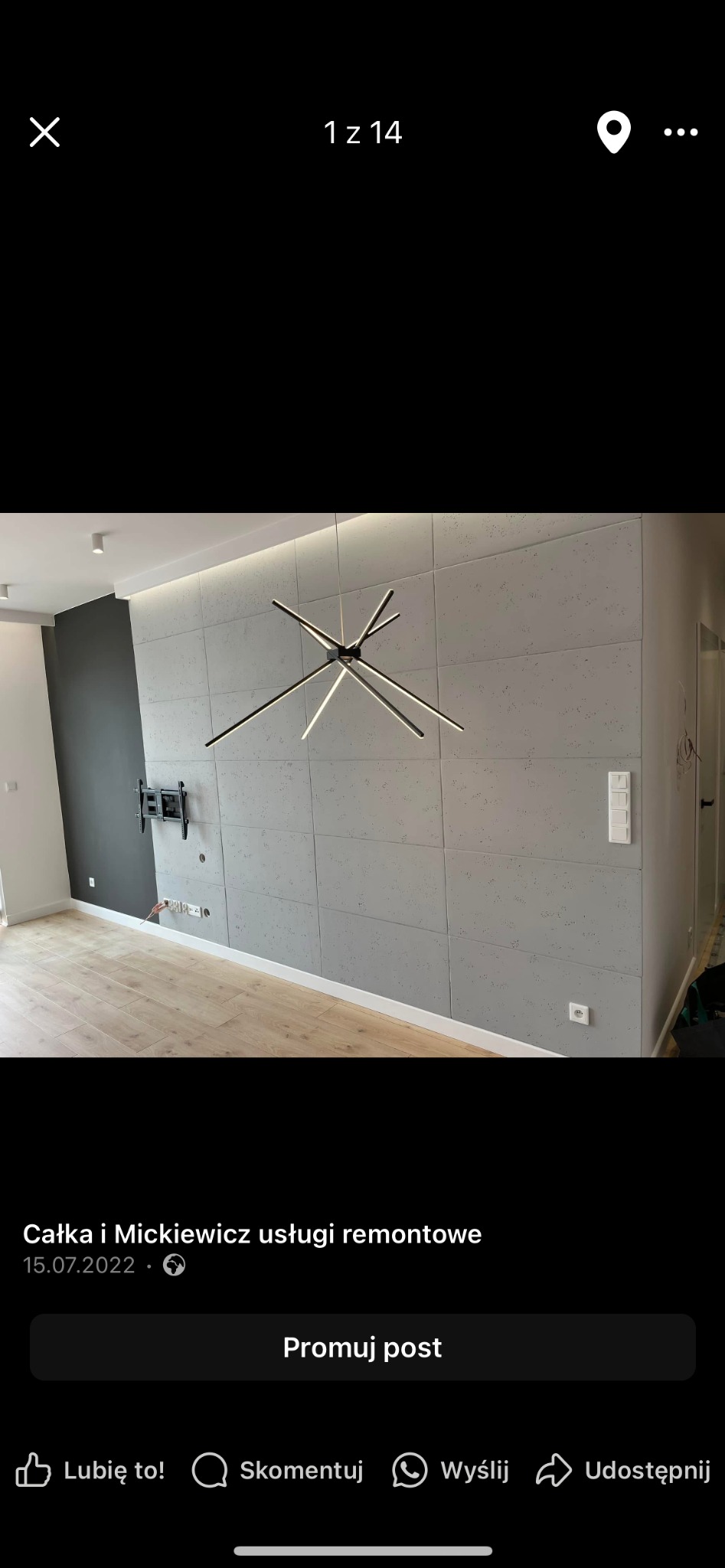 Nowoczesne wykończenie wnętrza: ściana z paneli imitujących beton, minimalistyczna lampa, drewniana podłoga i uchwyt na telewizor. Eleganckie i surowe.