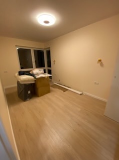 Jasne wnętrze po remoncie: panele podłogowe, pomalowane ściany w odcieniach beżu, okno z widokiem na zewnątrz. Częściowo widoczne materiały budowlane.