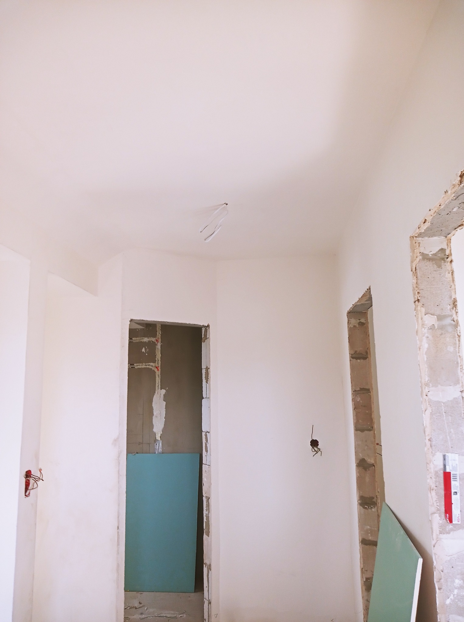 Wnętrze w trakcie prac w Markach: przygotowane ściany, widoczne płyty karton-gips i instalacje elektryczne przed wykończeniem.