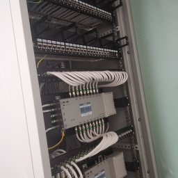Firma Elektryczna D-Volt Daniel Kruczek - Szafa telekomunikacyjna z patch panelem, kablami koncentrycznymi i multiswitchem TERRA MR532. Instalacja kablowa wewnątrz szafy rack, widok od frontu.