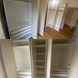 Wood Vibes Only - Białe, otwarte szafy wnękowe z szufladami i półkami, widoczne na drewnianej podłodze. Część szaf jeszcze w trakcie montażu, surowe wnętrze, jasne oświetlenie.