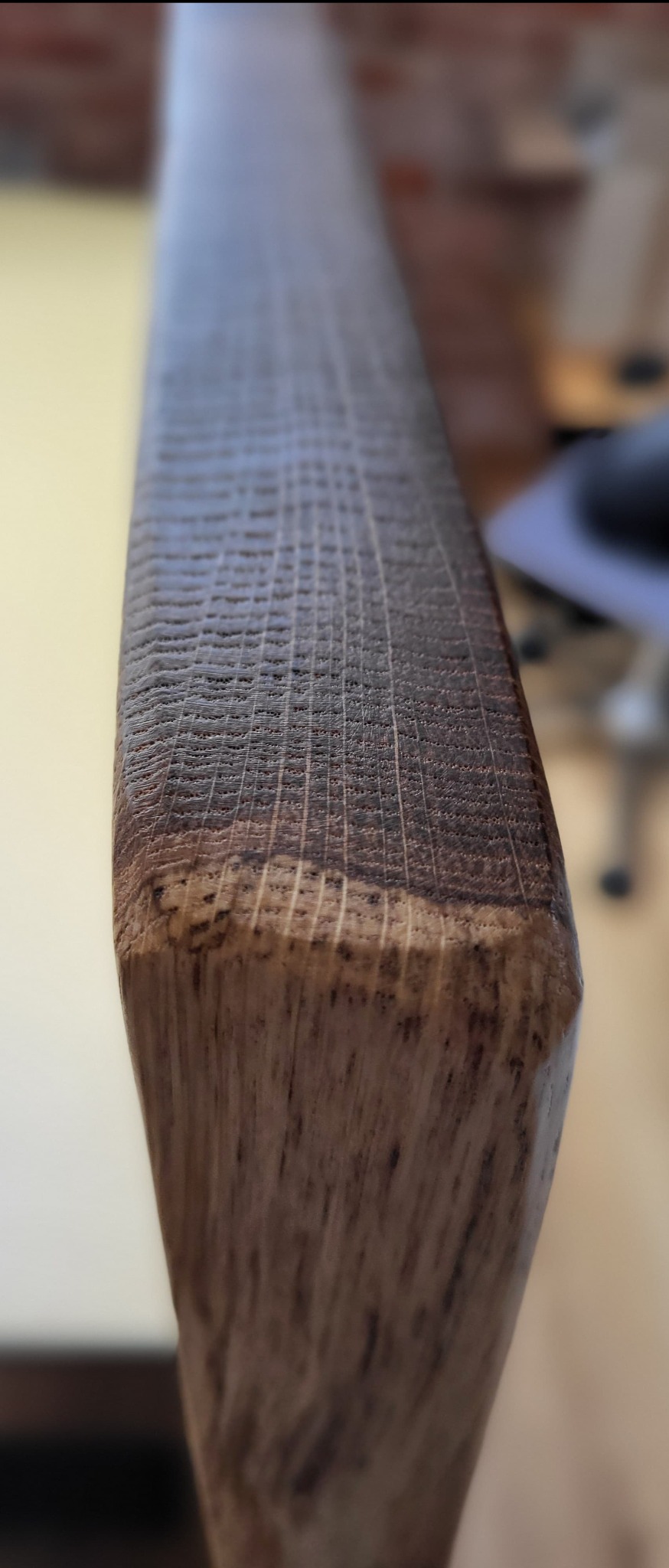 Szczegółowe ujęcie bejcowanej deski drewnianej z wyraźnym usłojeniem i delikatną fakturą, ukazujące precyzję obróbki i naturalne piękno materiału.