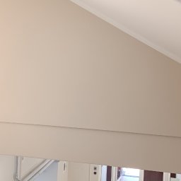 Ruslan Kostenko - Jasne ściany po malowaniu w klatce schodowej budynku. Widoczne detale wykończenia i przygotowane narzędzia malarskie. Ujęcie z góry.