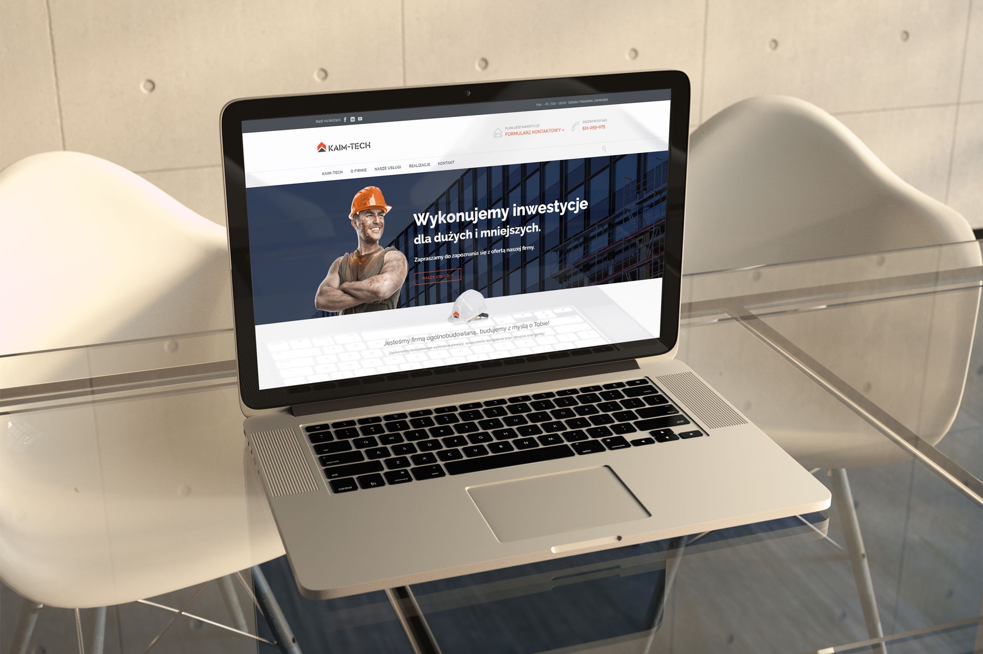 Laptop na szklanym stole prezentuje stronę internetową firmy budowlanej z hasłem 'Wykonujemy inwestycje dla dużych i mniejszych'. W tle nowoczesne krzesła i betonowa ściana.