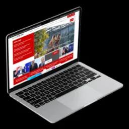 Laptop prezentuje stronę internetową z artykułami informacyjnymi, wyróżniającą się układem graficznym i czytelną typografią na jasnym tle.