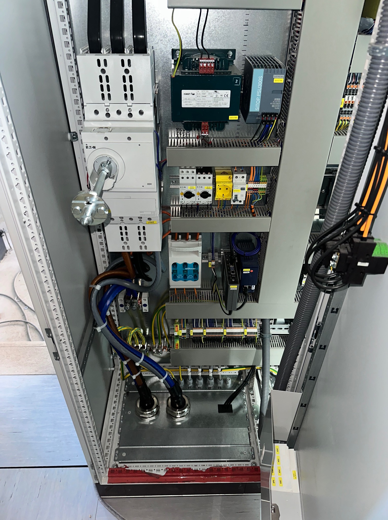 Rozdzielnica elektryczna z zamontowanymi bezpiecznikami i przewodami w szafie sterowniczej. Usługi elektryczne w Warszawie.