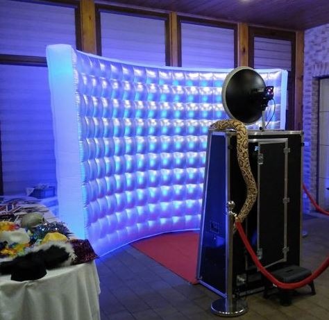 Innowacyjna, dmuchana ścianka z niebieskim podświetleniem i automat do zdjęć z rekwizytami.  Czerwony dywan i złoty wąż dekoracyjny dodają elegancji.
