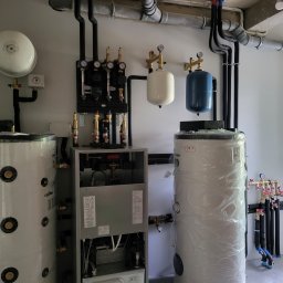 FHU Maciej Malinowski Intertrans - Złożony system grzewczy z dwoma zbiornikami, rozdzielaczami i pompami, instalacja hydrauliczna z rurami i zaworami.
