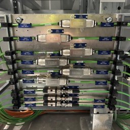 EKSS Jakub Klimontowicz - Szczegółowe ujęcie panelu z przewodami i złączkami Siemens, oznaczonymi etykietami, zamontowanego w metalowej konstrukcji. Widoczne kable w kolorze zielonym i pomarańczowym.