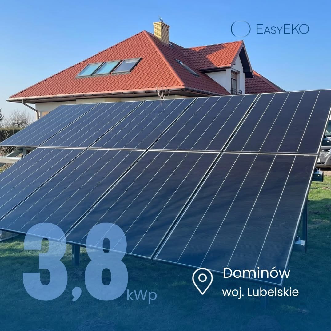 Instalacja fotowoltaiczna 3.8 kWp na trawniku przed domem z czerwoną dachówką i trzema oknami dachowymi w Dominowie, woj. Lubelskie. Słoneczny dzień.