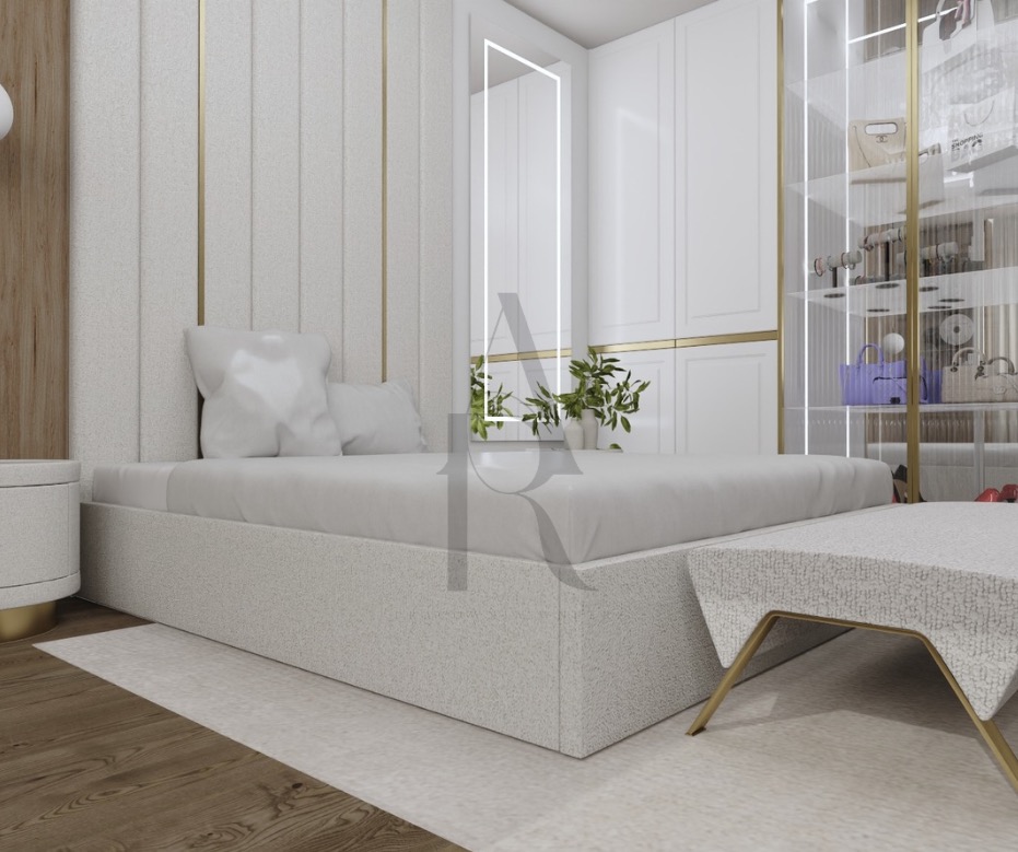 Nowoczesna sypialnia: tapicerowane łóżko w odcieniach bieli, złote akcenty, garderoba z przeszklonymi drzwiami, minimalistyczny stolik nocny i drewniana podłoga.