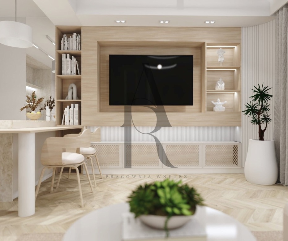 Jasne drewno i biel w aranżacji salonu z telewizorem, półkami i roślinami doniczkowymi. Minimalistyczne krzesła przy blacie. Parkiet w jodełkę.