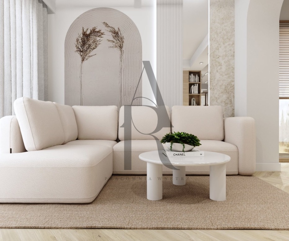 Jasny, narożny tapicerowany zestaw wypoczynkowy z okrągłym stolikiem kawowym i rośliną doniczkową na tle minimalistycznej ściany z dekoracyjnym łukiem.
