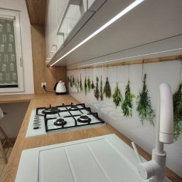 MEBLEMATE MATEUSZ RYNDAK - Jasna kuchnia z drewnianym blatem, białym zlewem Franke i płytą gazową. Nad blatem panel z motywem ziół i białe szafki podświetlone LED. Nowoczesny design.