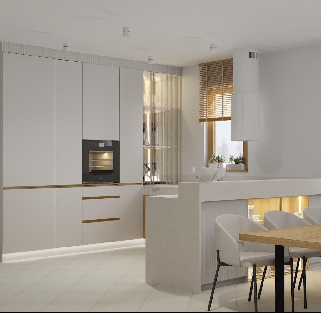 Minimalistyczna kuchnia z białymi frontami, drewnianymi akcentami i ażurową ścianką działową. Widoczny blat z wyspą i krzesła w jasnej tonacji.