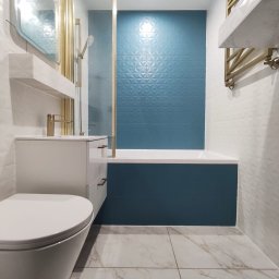 Dav-Bau Dawid Górecki - Nowoczesna łazienka po remoncie: biało-turkusowe płytki z geometrycznym wzorem, złota armatura, wisząca szafka z umywalką i toaleta. Marmurowe płytki podłogowe.