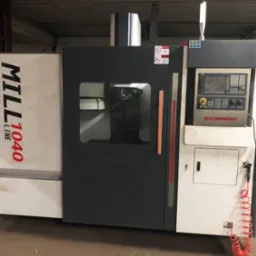 Szara frezarka CNC MILL LINE 1040 z panelem sterowania CORMAK, widoczna w hali produkcyjnej, z przewodem pneumatycznym zwisającym z boku.