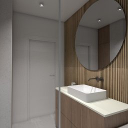 Projektowana - Daria Ciosek - Nowoczesna łazienka z okrągłym lustrem na tle drewnianej ściany. Biała umywalka nablatowa z czarną armaturą. Minimalistyczny design, jasna kolorystyka, subtelne oświetlenie.