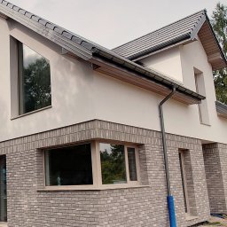 Dolna część elewacji z cegły, tynk typu baranek 1,5mm. Podbitka dachowa z drewna 