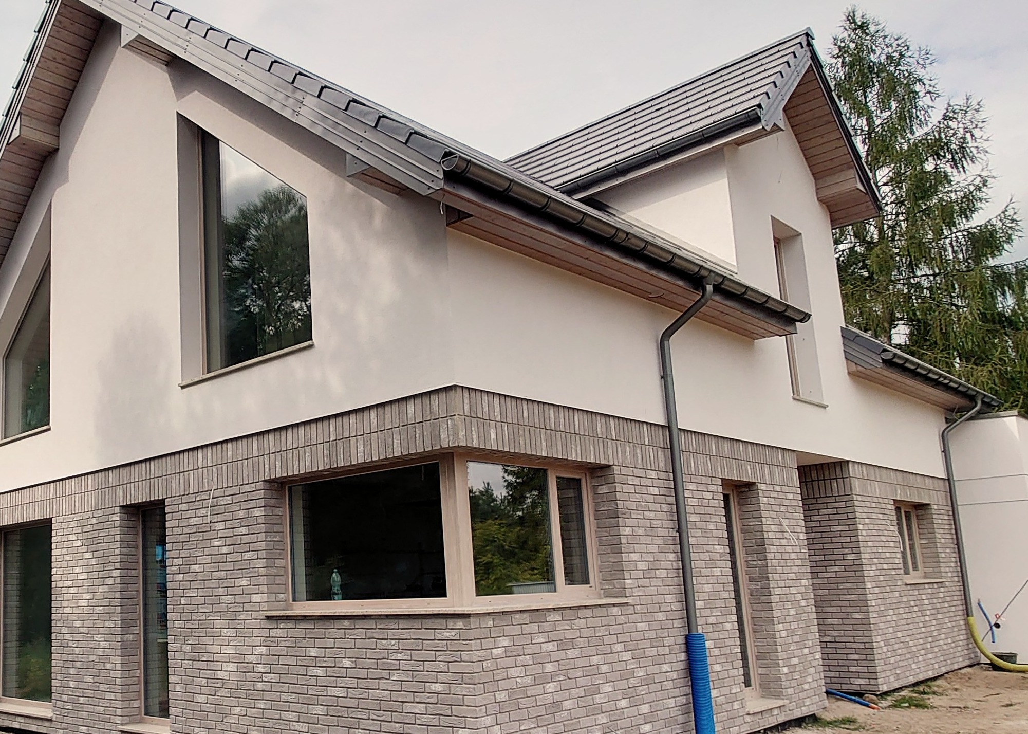 Dolna część elewacji z cegły, tynk typu baranek 1,5mm. Podbitka dachowa z drewna