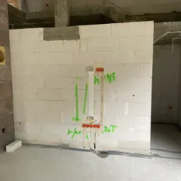 Instalacja elektryczna w ścianie z betonu komórkowego, widoczne puszki i przewody. Prace w toku w Mszanie Dolnej.