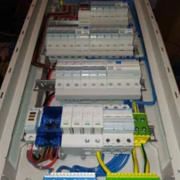 Rozdzielnia elektryczna z zainstalowanymi bezpiecznikami, zabezpieczeniami przepięciowymi i okablowaniem, widok z góry.