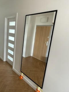 lustro w czarnej ramce w przedpokoju, robi robotę