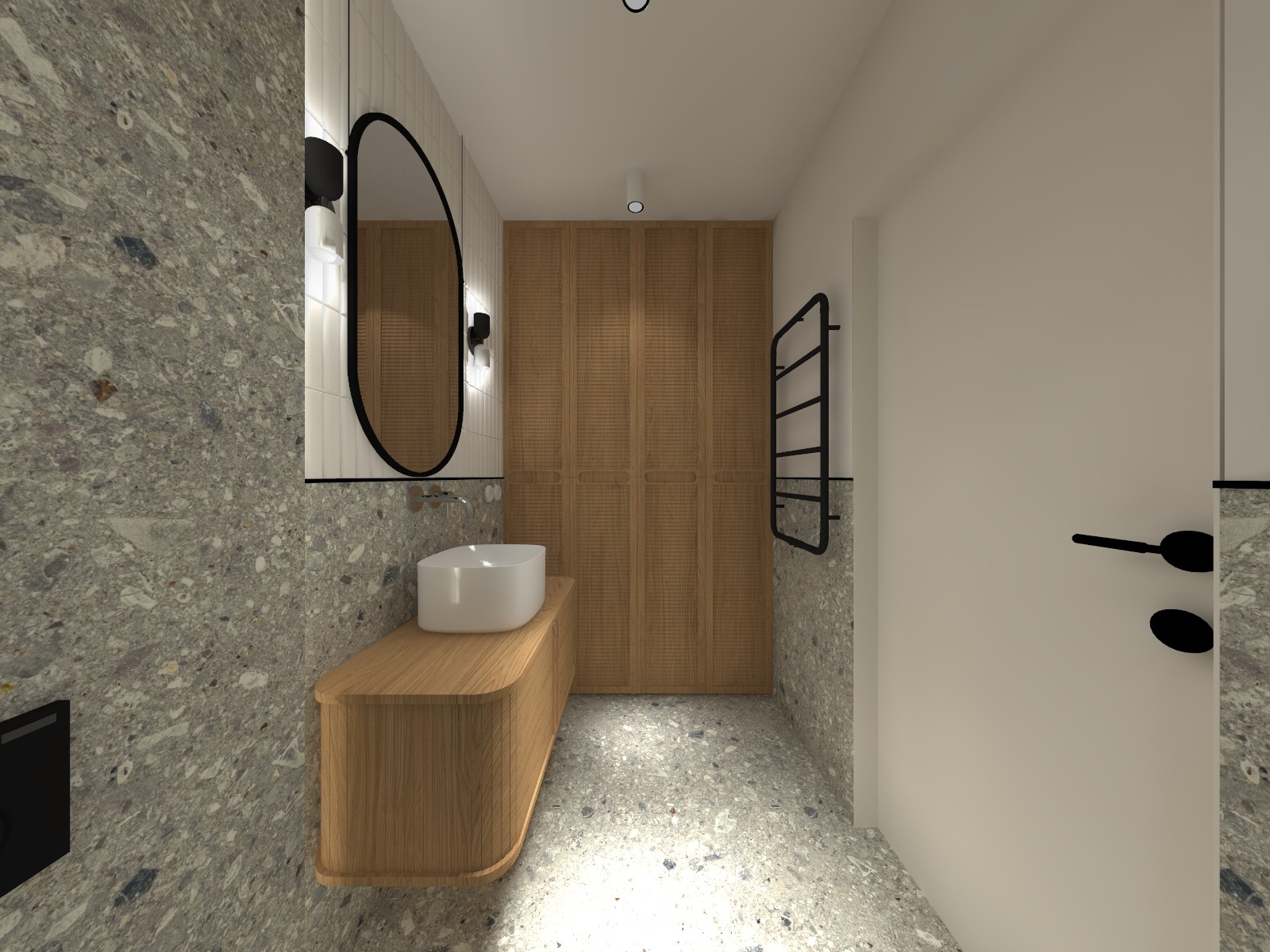 Nowoczesna łazienka z umywalką nablatową na drewnianej szafce, owalnym lustrem w czarnej ramie i płytkami imitującymi lastryko na ścianach i podłodze.