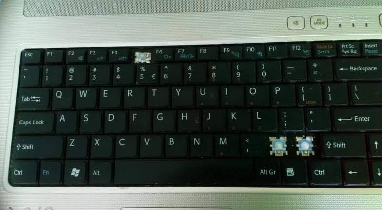 Uszkodzona klawiatura laptopa z brakującymi klawiszami. Widoczne mechanizmy pod klawiszami. Potencjalna usługa naprawy lub wymiany klawiatury.