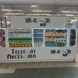 Stoisko z akcesoriami do telefonów w centrum handlowym, prezentujące etui, szkła ochronne i karty SIM. Widoczne logo 'HA-KO-JA mobile'.