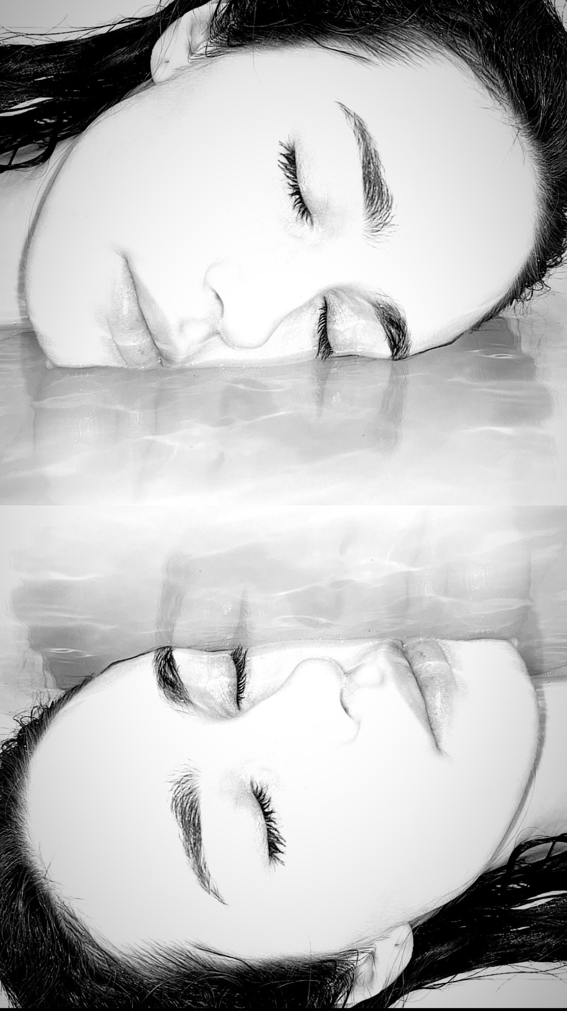 Monochromatyczne odbicie twarzy kobiety z zamkniętymi oczami, uchwycone w minimalistycznej kompozycji z efektem lustrzanego odbicia w wodzie.