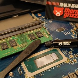 BIUROTECH - SERWIS ŁUKASZ HIPP - Otwarty laptop z widoczną płytą główną, procesorem, pamięcią RAM i pastą termoprzewodzącą Thermal Grizzly. Detaliczna naprawa sprzętu komputerowego.