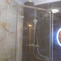Glazrem - Kabina prysznicowa z deszczownicą i półkami narożnymi, wykończona marmurem w odcieniach beżu i granatu. Realizacja w łazience w Warszawie.