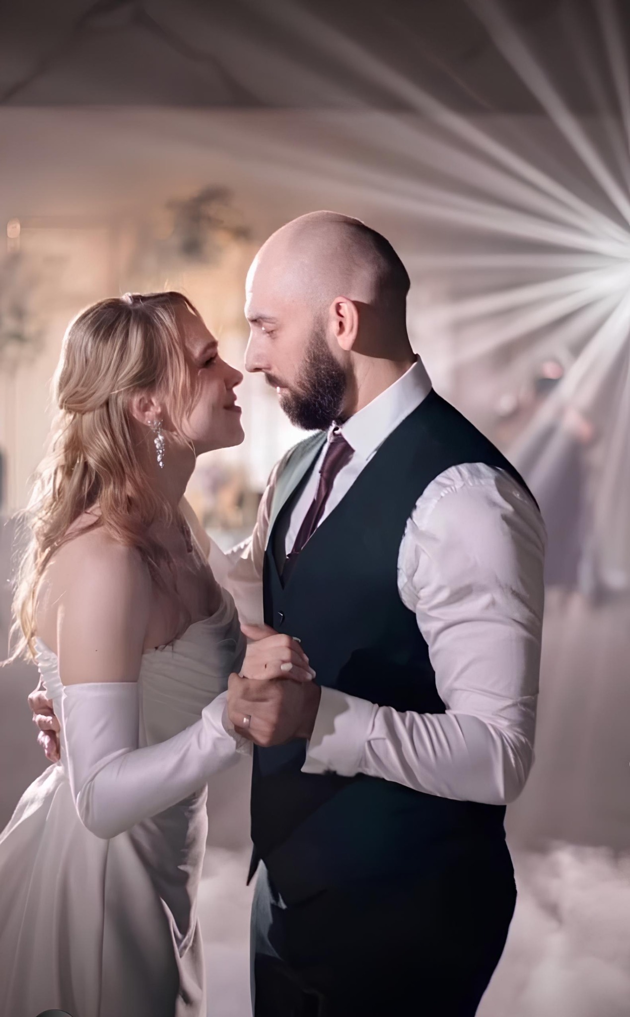 Para młoda w tańcu, subtelne światło podkreśla intymną chwilę. Panna młoda w białej sukni i długich rękawiczkach, pan młody w eleganckiej kamizelce.