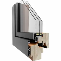 Przekrój ramy okiennej z potrójnym szkleniem, ukazujący detale konstrukcyjne i izolację termiczną. Szara rama aluminiowa łączy się z drewnianym elementem.