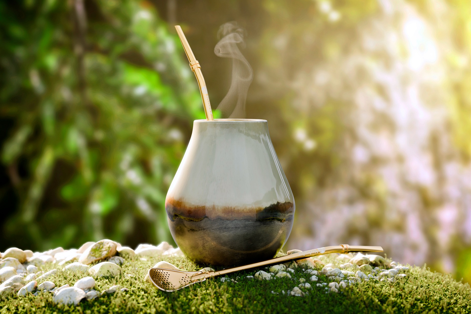 Stylowa wizualizacja naczynia do yerba mate z bombillą i unoszącą się parą, umieszczona na kamiennym podłożu z mchem na tle zieleni.