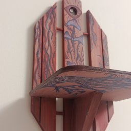 Magdalena Wiejacha - Ręcznie malowana, drewniana półka w stylu boho z motywami roślinnymi i okiem, zawieszona na białej ścianie. Unikalny design i artystyczne wykończenie.