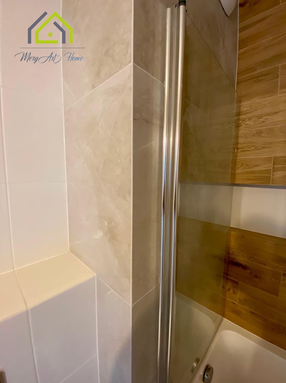 Wykończona łazienka z kabiną prysznicową i różnymi rodzajami płytek na ścianach, prezentująca efekt po remoncie.