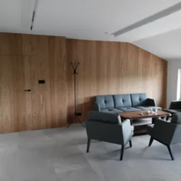 Nowoczesny salon z ścianą wyłożoną drewnianymi panelami, ukrywającymi drzwi. Szara sofa i fotele ustawione wokół drewnianego stolika kawowego. Minimalistyczny design.