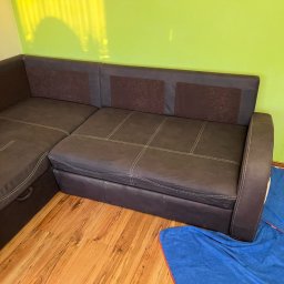 Błysk AutoSPA Nysa - Ciemnobrązowy narożnik z funkcją spania, po praniu, na podłodze leżą niebieskie ścierki i spryskiwacz. Widoczne jasne przeszycia na tapicerce.